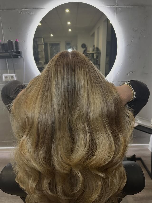 Nahaufnahme eines blonden Balayage-Verlaufs in gewelltem Haar